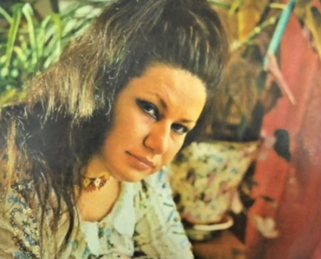 ileana sararoiu fotografie color cu parul lung si codite de tus la ochi imbracata cu o bluza colorata