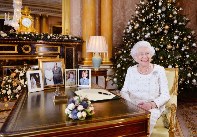 Regina Elisabeta a II a stă la o masă din camera 1844 din Palatul Buckingham, Londra. 