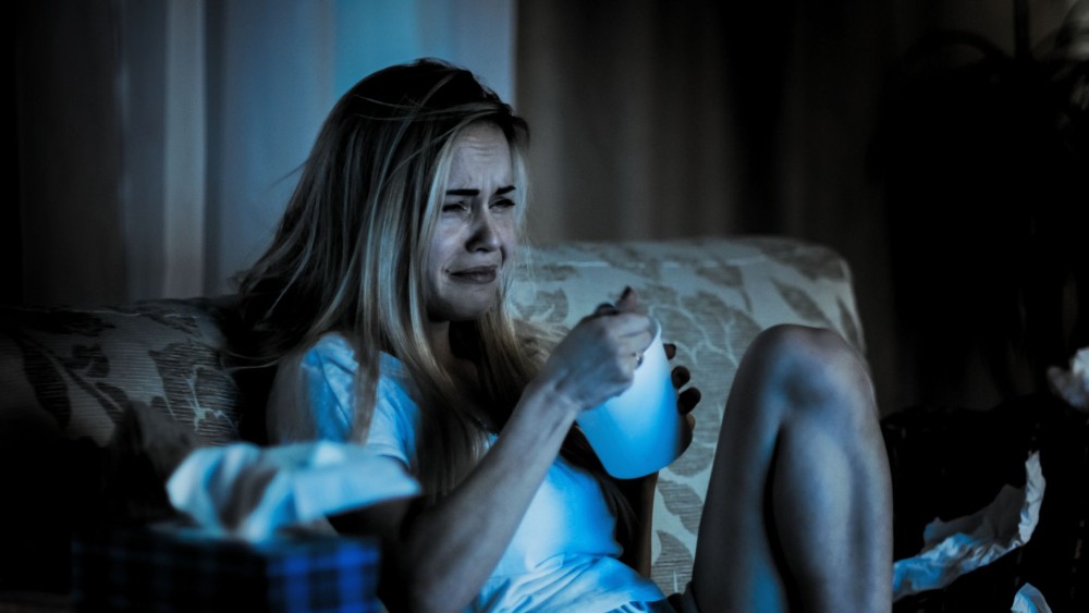 Imagine cu o femeie tristă care plânge și mănâncă