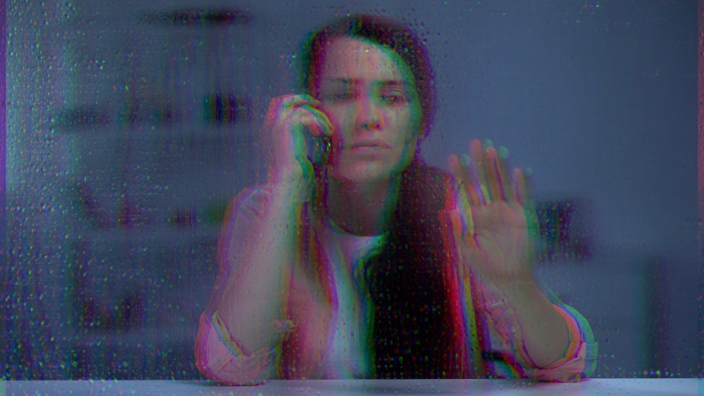 Imagine cu o femeie tristă care se uită pe geam