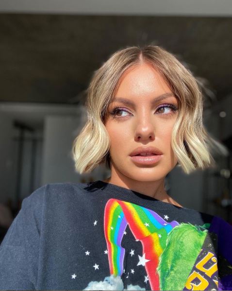 Alexandra Stan machiată și cu tricou negru cu un curcubeu pe ea, face un selfie