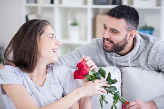 Imagine cu un bărbat care îi oferă flori unei femei
