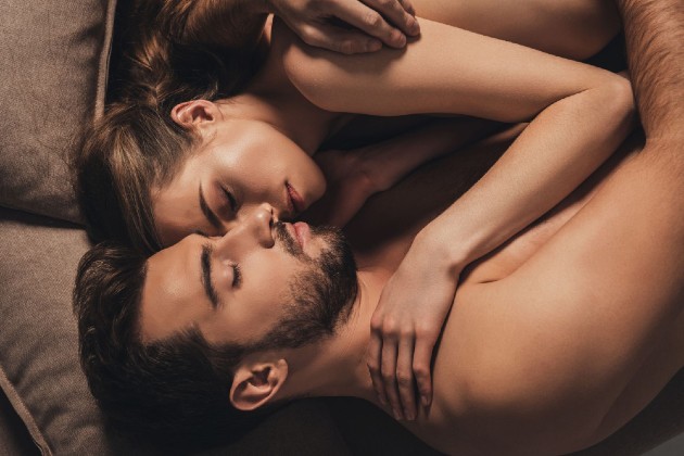 Imagine cu o femeie și un bărbat care se țin în brațe în pat