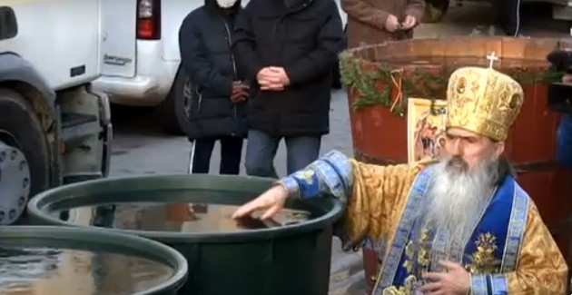 Imagine cu un preot care sfințește apa de Bobotează