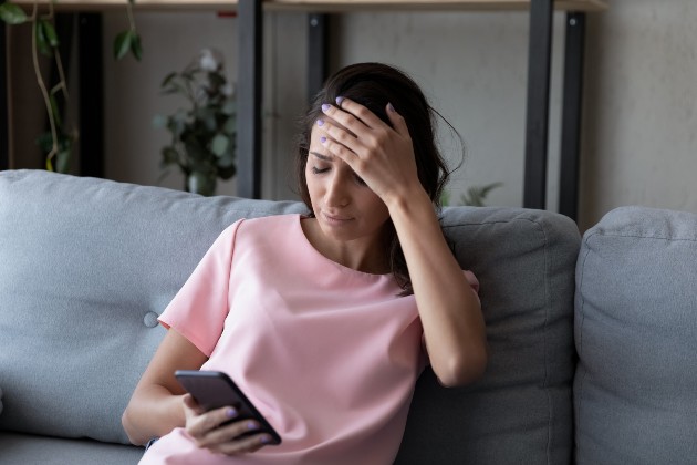 Imagine cu o femeie dezamăgită care se uită la telefon