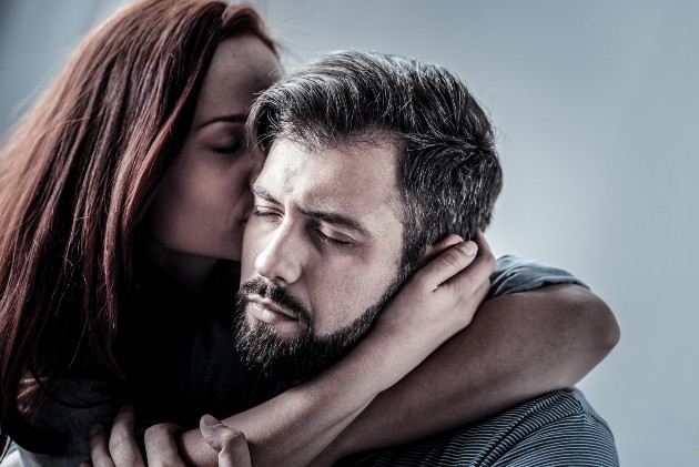 Imagine cu un bărbat trist care este îmbrățișat de o femeie