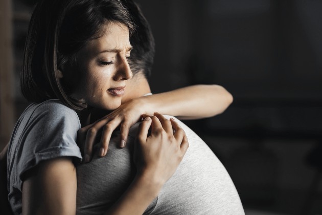 Imagine cu o femeie care plânge în brațele unui bărbat