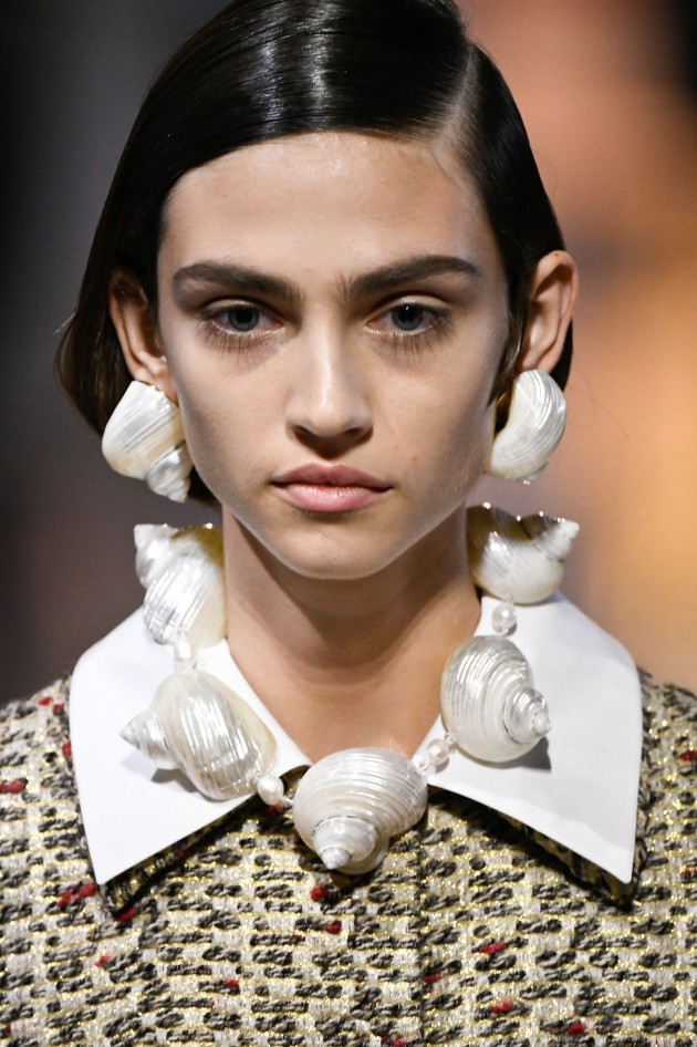 Imagine cu un model care poartă accesorii cu scoici la o prezentare de modă Prada, Milan Fashion Week Spring/Summer 2020