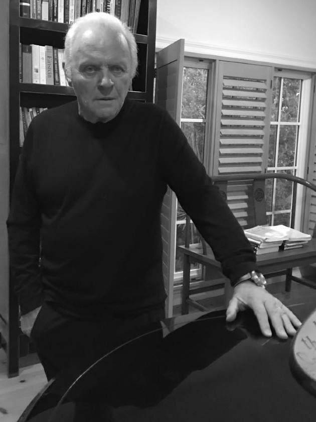 Imagine alb negru cu Anthony Hopkins în timp ce se rezeazmă de o masă
