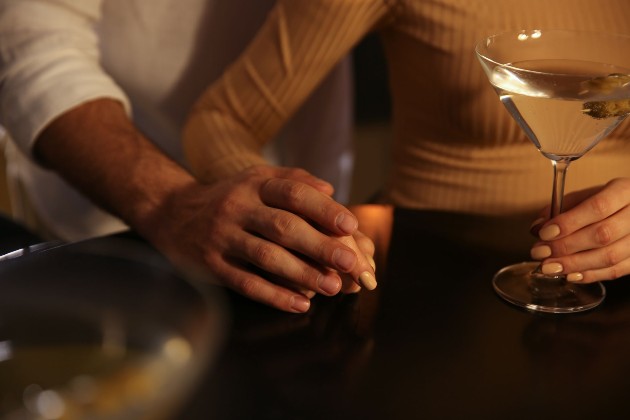 Imagine cuo femeie și un bărbat care se țin de mână în restaurant