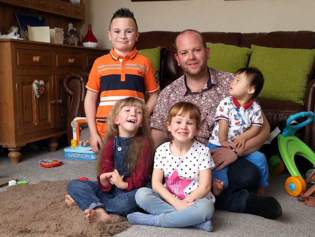 Imagine cu Ben Carpenter și cei cinci copii ai săi în timp ce stau pe podea 