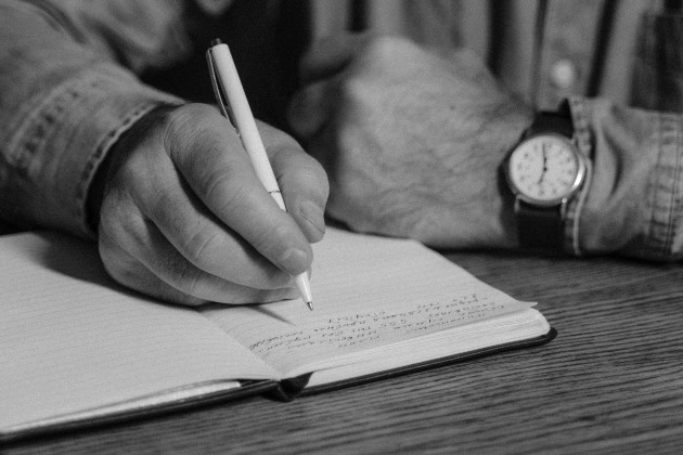 Imagine alb-negru cu un bărbat care scrie