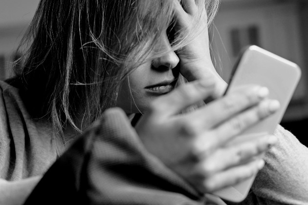 Imagine alb-negru cu o femeie care ține un telefon în mână