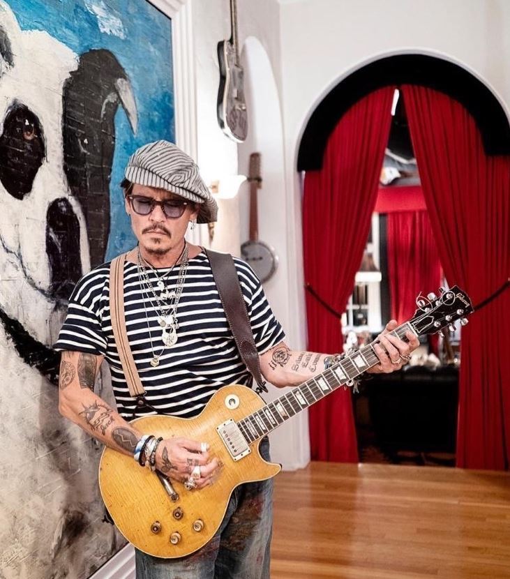 Imagine cu Johnny Depp în timp ce cântă la chitară