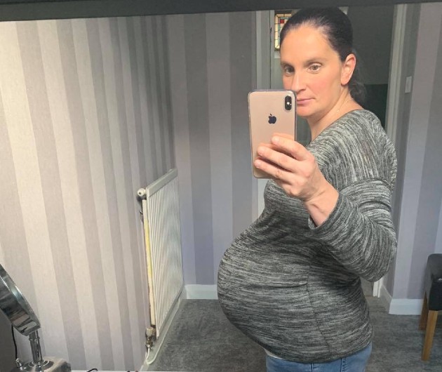Imagine cu Sue gravidă în timp ce face o poză în oglindă