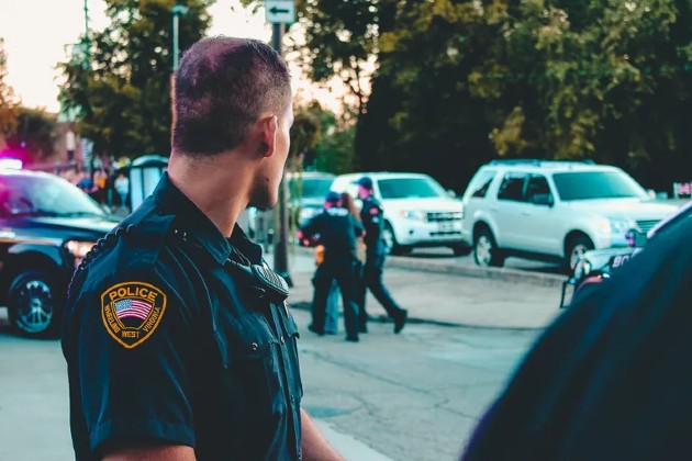 Imagine cu un polițist care stă cu spatele