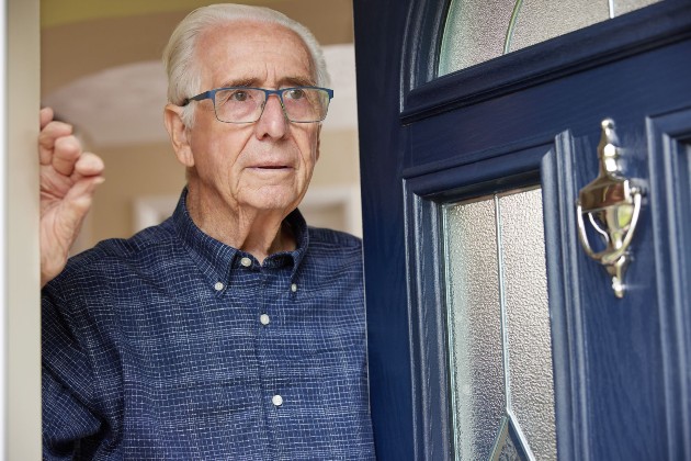 Imagine cu un bărbat în vârstă care stă în ușă