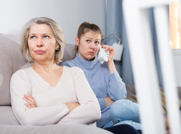 Imagine cu o femeie și mama sa în timp ce stau pe canapea supărate