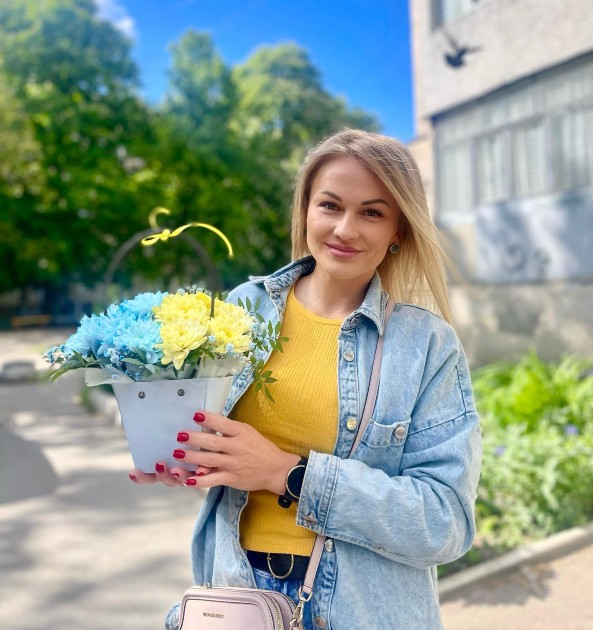 Imagine cu Yulia Chernitskaya ținând un buchet de flori în mâini