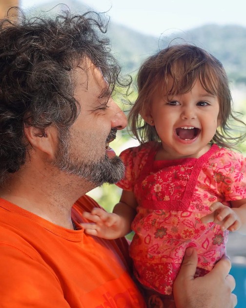 Imagine cu Lia în timp ce râde în brațele tatălui ei
