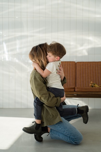 Imagine cu o femeie care ține un băiețel în brațe