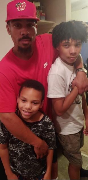 Imagine cu Daniel Smith îmbrăcat în roșu alături de doi dintre copiii săi