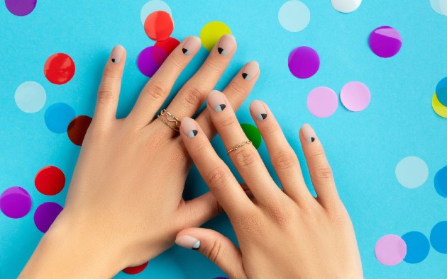 Imagine cu mâini de femeie cu confetti colorate pe fundal albastru