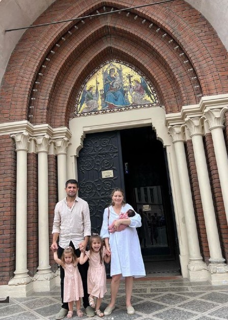 Imagine cu Laura Cosoi în fața unei biserici alături de familia sa