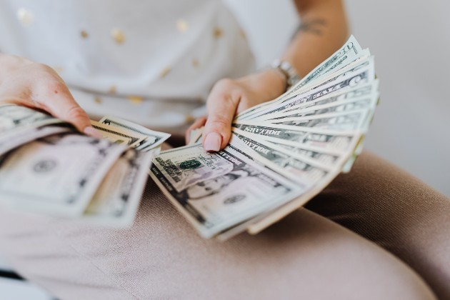 Imagine cu o femeie care întinde bani
