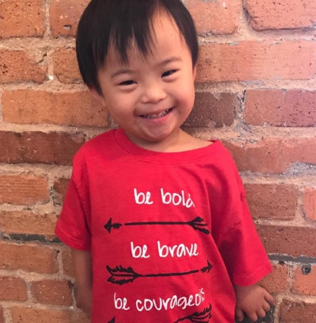 Imagine cu Mx, copilul chinez cu sindrom Down, în timp ce zâmbește