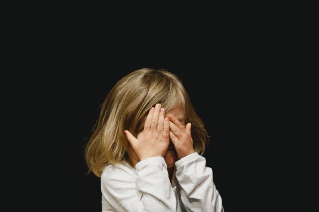 Imagine cu o fetiță blondă cu codițe care plânge