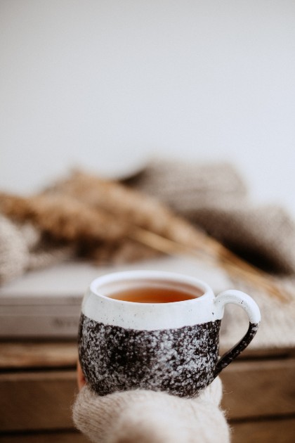 Imagine cu mână unei femei care ține o ceașcă cu ceai