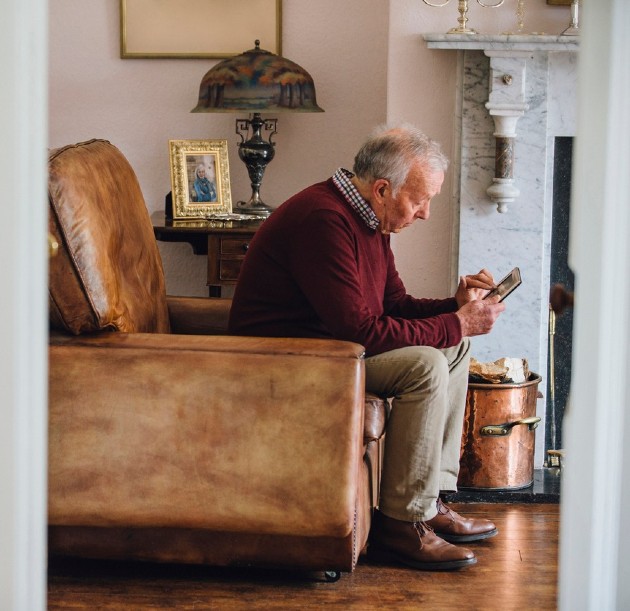 Imagine cu un bărbat bătrân care se uită la telefon