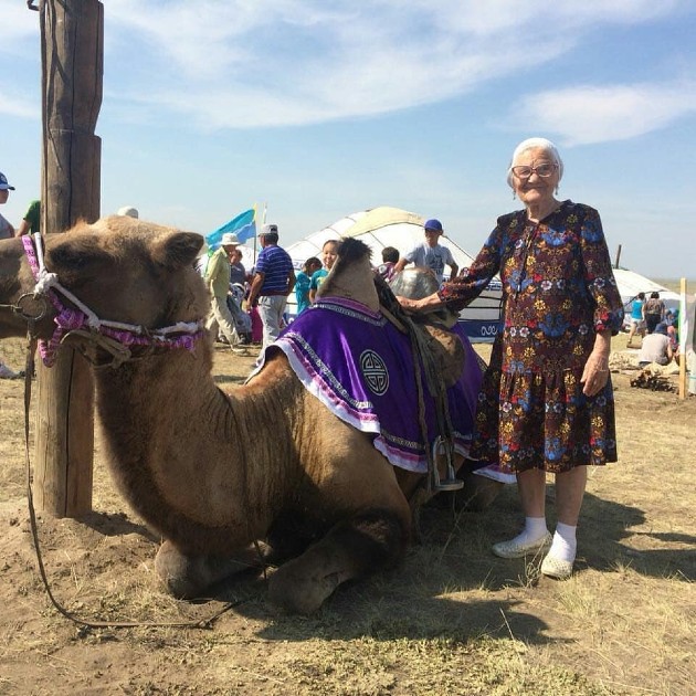 Imagine cu Baba Lena Erkhova în vacanță alături de o cămilă