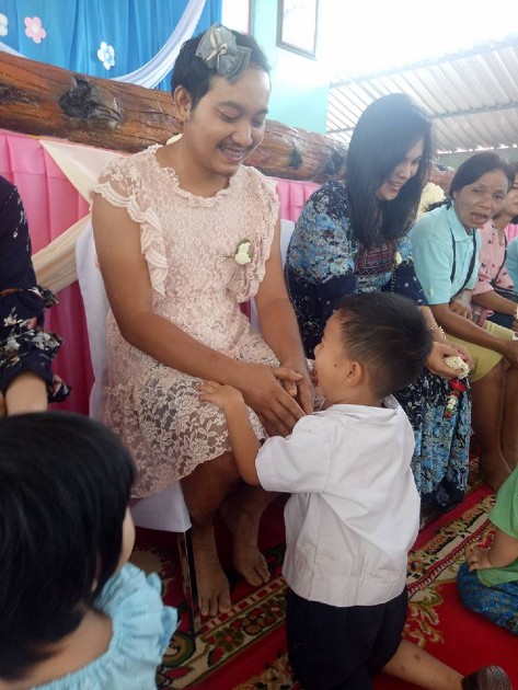 Imagine cu  Chatchai “Sam” Panuthai îmbrăcată în rochiță, alături de copilul său