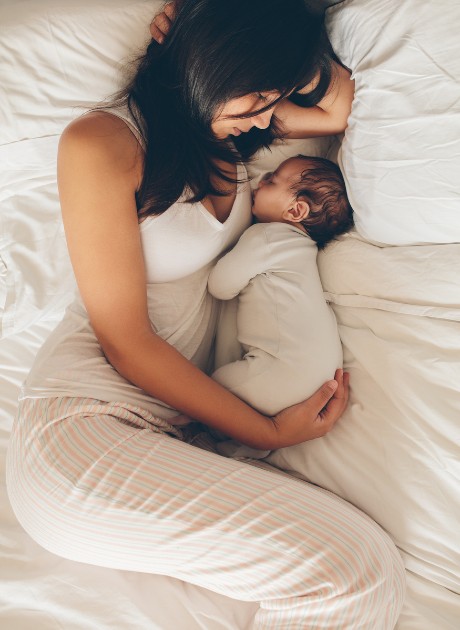 Imagine cu o mămică care stă cu bebelușul în brațe
