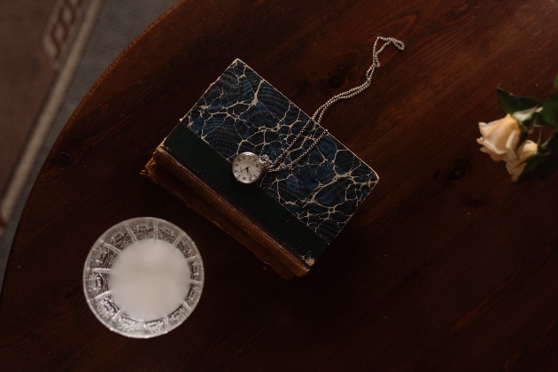 Imagine cu un jurnal vechi lângă un ceas de geantă