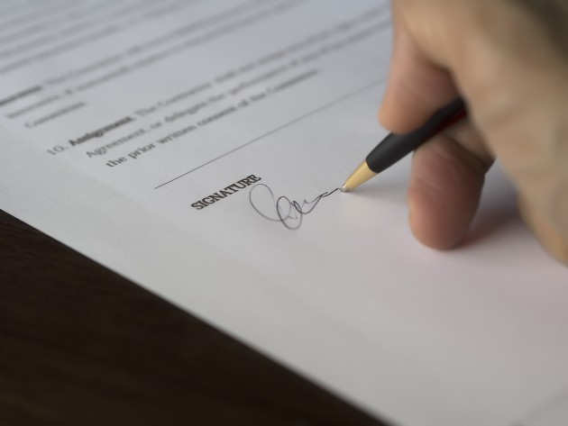 Imagine cu o femeie care semnează un contract