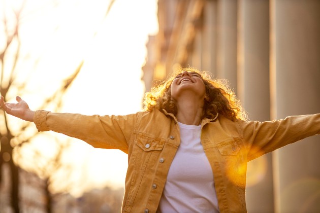 Imagine cu o femeie fericită care privește către cer