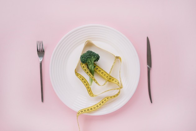 Imagine cu o bucată de broccoli și o bandă de măsurare pe o farfurie