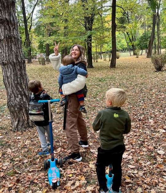 Imagine cu Adela Popescu și cei trei copii ai ei în parc