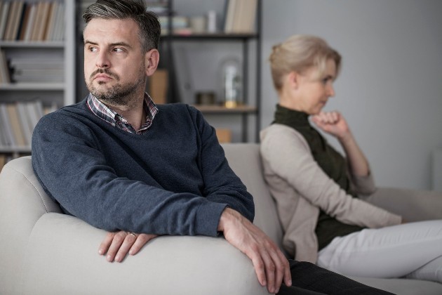 Imagine cu un soț care stă supărat lângă soția sa
