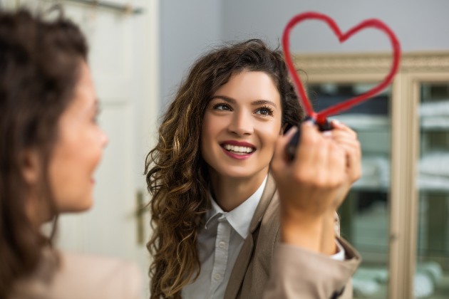 Imagine cu o femeie care desenează o inimă pe oglindă