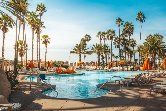 Imagine cu o piscină înconjurată de palmieri