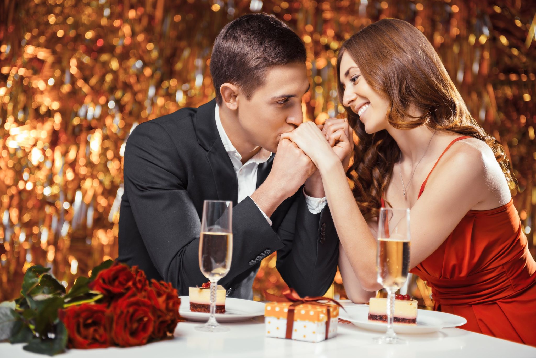 Cuplu la o intalnire de Sfantul Valentin, barbatul ii saruta mana partenerei