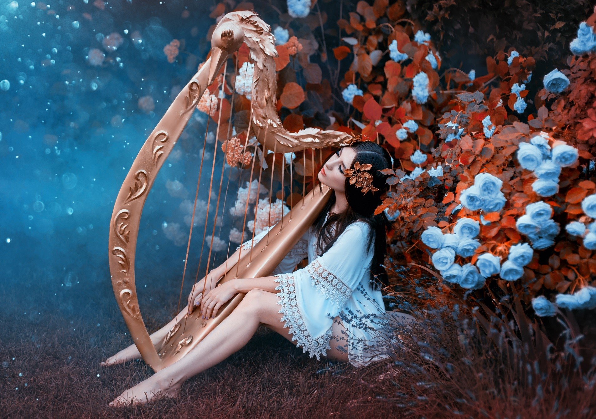 Femeie imbracata intr-o rochie alba, asezata in sezut, canta la harpa intr-un decor cu flori