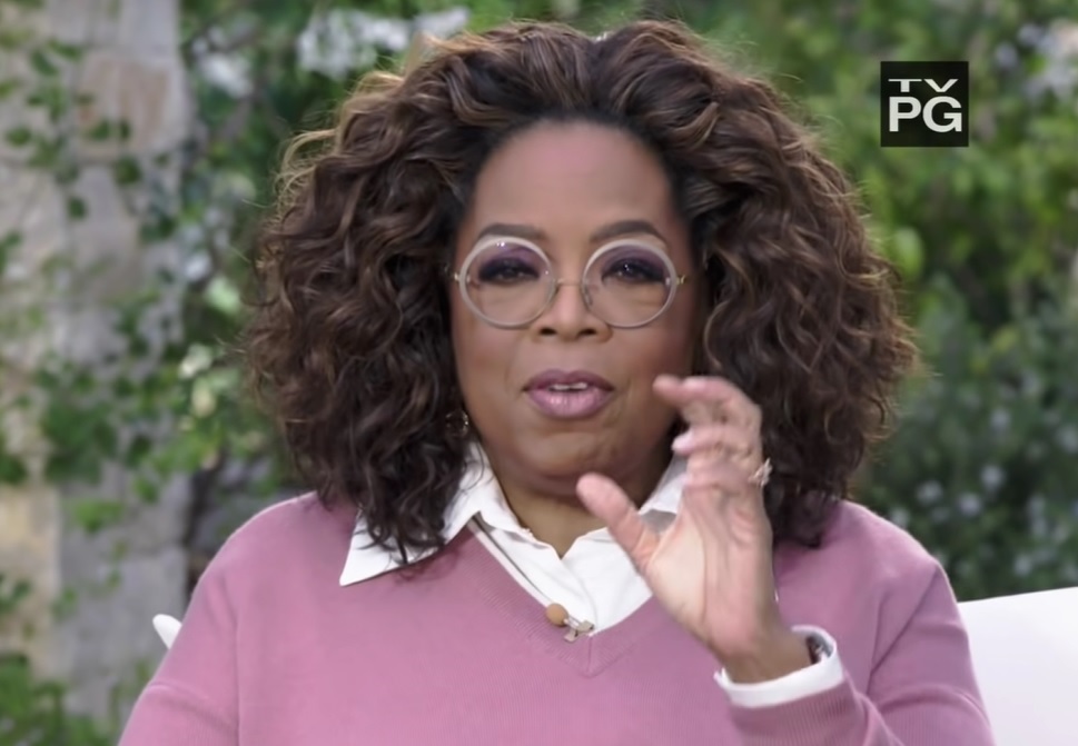  oprah winfrey vorbeste si gesticuleaza, sta asezata pe scaun in timpul interviului cu printul harry si meghan markle
