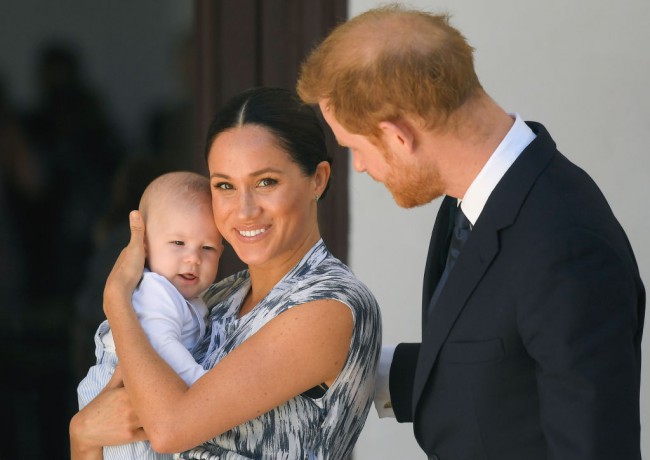 meghan markle il tine in brate pe archie, in timp ce printul harry in priveste pe amandoi