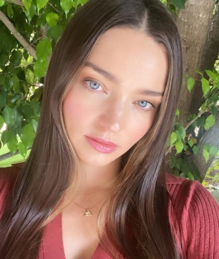 miranda kerr, fara machiaj, zambeste subtil in timp ce se uita in fata