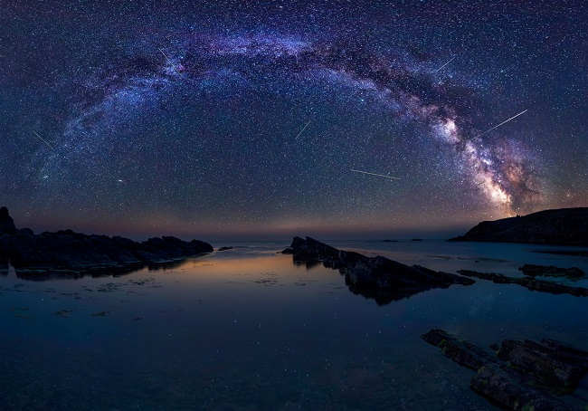 peisaj cu un lac si cerul instelat, in timpul unei ploi de meteoriti